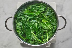 spinach in water in pot on burner