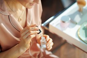 woman applying retinol treatment to face