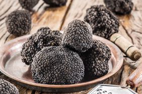 Black truffles on the plate on the old wooden table