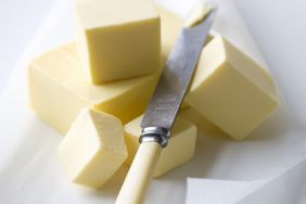 Blocks of butter with butter knife on parchment paper