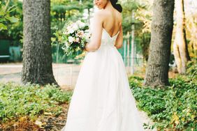 woman standing in garden in wedding dress- classic hair and makeup