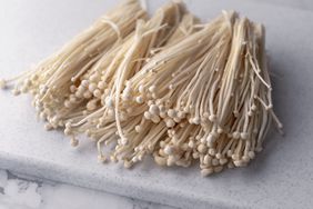 enoki mushrooms on cutting board