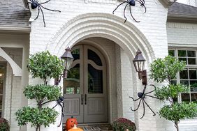 side view of fall porch with large spiders hay and pumpkins