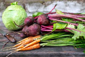 Fresh carrots, beets and cabbage on wooden background, selective focus