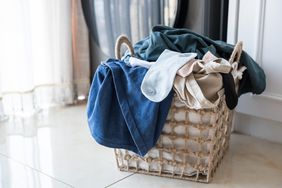 laundry basket sits on floor full of clothes