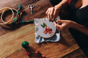 Woman embroidering flowers on fabric