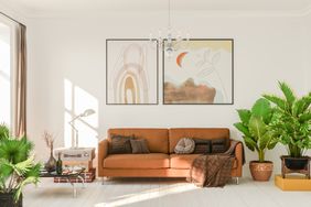 A white living room with a brown leather sofa