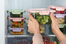 Woman taking container with broccoli from refrigerator