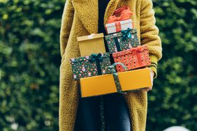 Woman holding stack of holiday gifts