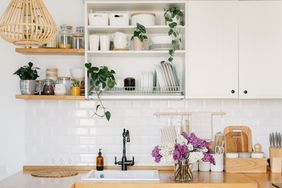 View on white kitchen in Scandinavian modern style, kitchen details. Open shelves storage. Sustainable living eco friendly kitchen.