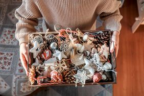 Person holding box of vintage Christmas tree ornaments 