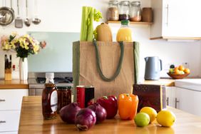 Groceries being unpacked in a modern kitchen - stock photo