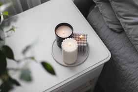 Luxury aroma burning candle in bedroom on bedside table.