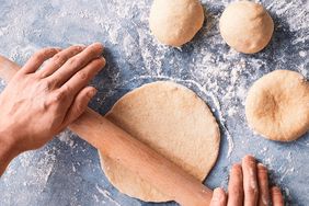 Bread being rolled with rolling pin