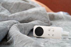 Controller of an electric blanket with a human sleeping at the background at horizontal composition