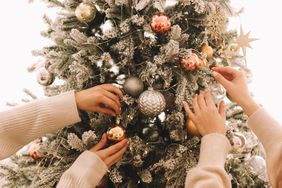 Two women putting ornaments on a christmas tree