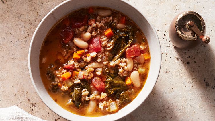 kale white bean and farro soup served in a white bowl