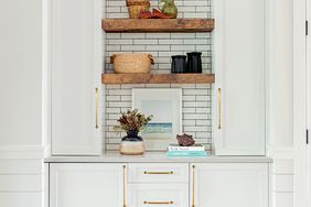 white butler's pantry with cabinets and tile backsplash