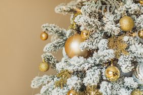 Luxury Christmas trees with artificial snow decorated with golden and white ornaments.