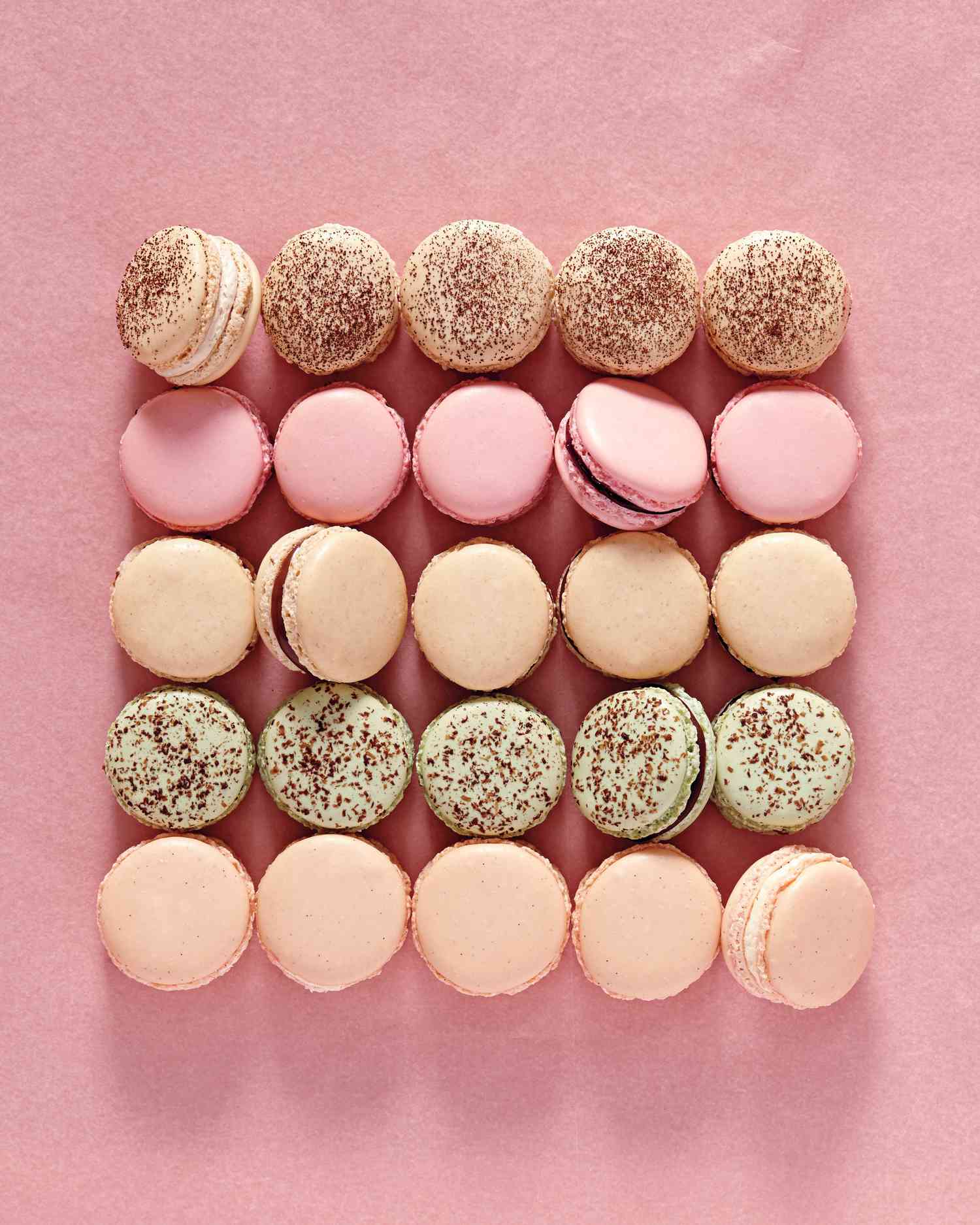 variety of french macarons on pink background