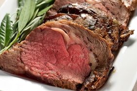 roast prime rib on a white plate with green garnish