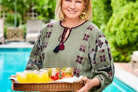 Martha Stewart standing by pool holding cocktail tray