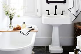 black and white bathroom with claw foot tub and pedestal sink