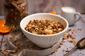 bowl of granola on a cutting board with spoon