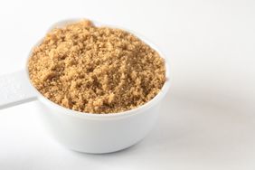 A measuring cup filled with packed brown sugar