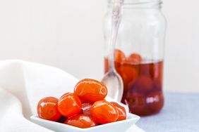 candied kumquats in dish with spoon and jar