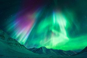 Northern Lights in the sky above snow-capped mountains. 