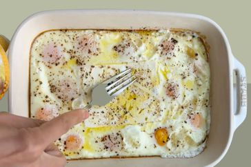 Eggs and feta cheese baked in a white dish. 