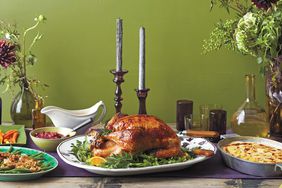 thanksgiving table with turkey, gravy, sides, and sauce