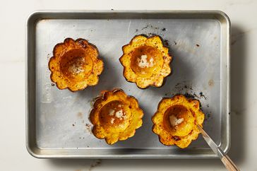 overhead view of cooked acorn squash on pan with knife