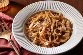 caramelized sliced shallots in a white bowl and serving fork