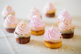 Pink cupcakes at white table in high light style.