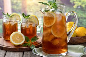 Pitcher of cold ice tea with rural summer background