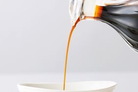 soy sauce being poured into a white dish