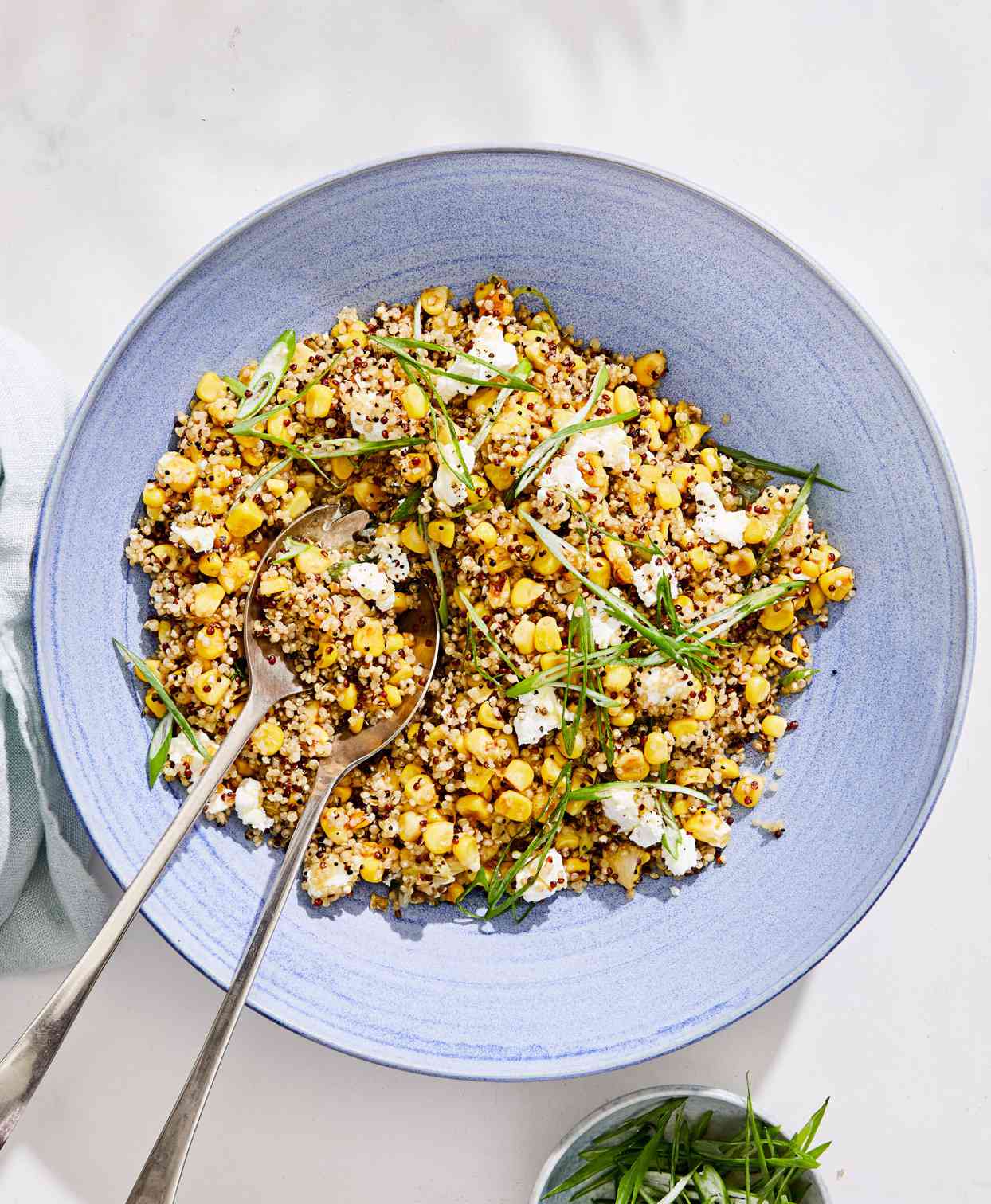 quinoa with caramelized corn and scallions served in a blue bowl