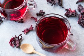 Red Hot Hibiscus Tea in a Glass Mug with Dry Hibiscus Tea Leaves.