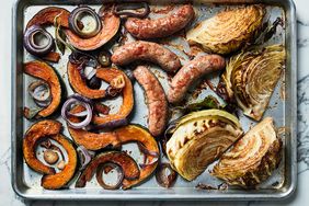 sausages cabbage vegetables on baking sheet