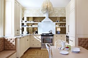 small kitchen with neutral color wallpaper and hanging light fixture