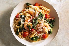 A bowl of pasta with shrimp and tomatoes