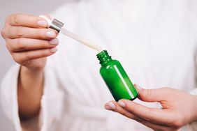 Woman holding tea tree oil in hands for skincare