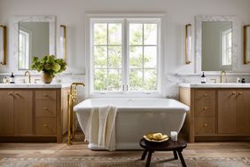 a bathroom with a beautiful tub and wood vanities