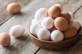 white and brown eggs in wood bowl