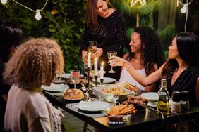 woman hosting dinner party outside in garden